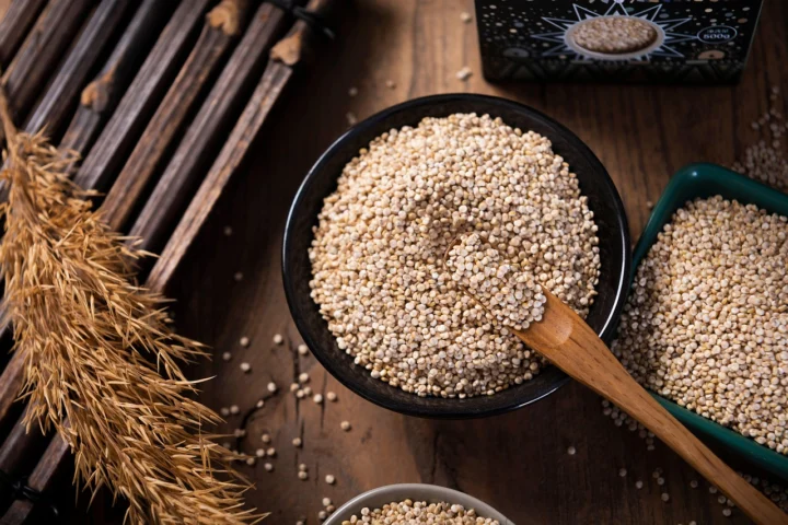 A bowl of fluffy cooked quinoa garnished with herbs